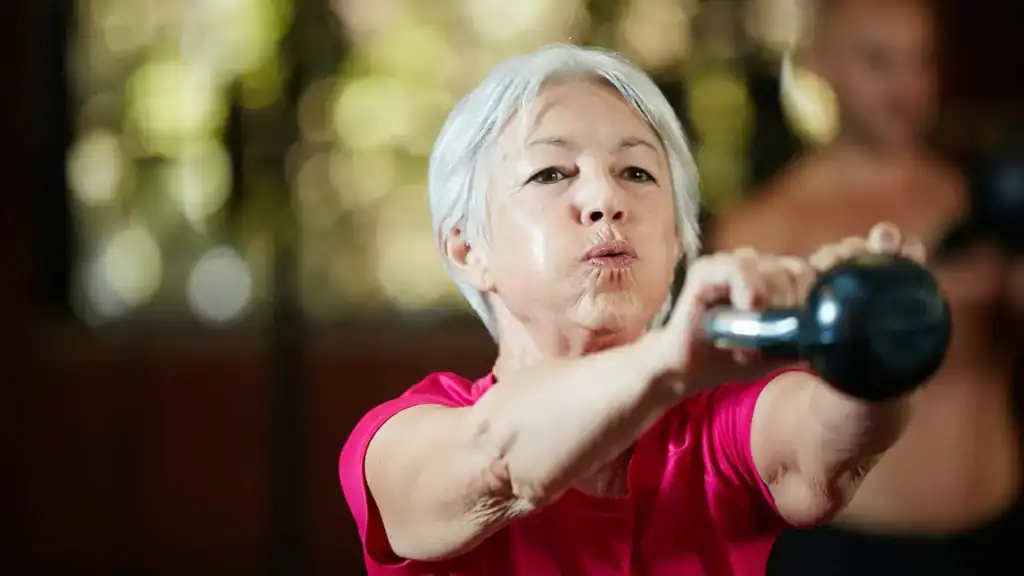 Toning Arms After 60: Empowering Womens Fitness Through Effective Weight Training 1 Older woman doing weight training Chelmsford to help her strength and longevity