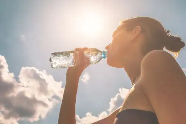 Hydration: The Secret Ingredient for a Toned Stomach and Enhanced Fitness 3 Image of woman drinking water to hydrate Chelmsford after run.