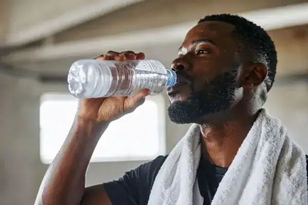 Hydration: The Secret Ingredient for a Toned Stomach and Enhanced Fitness 1 Image of man drinking water to improve hydration Chelmsford after work out.